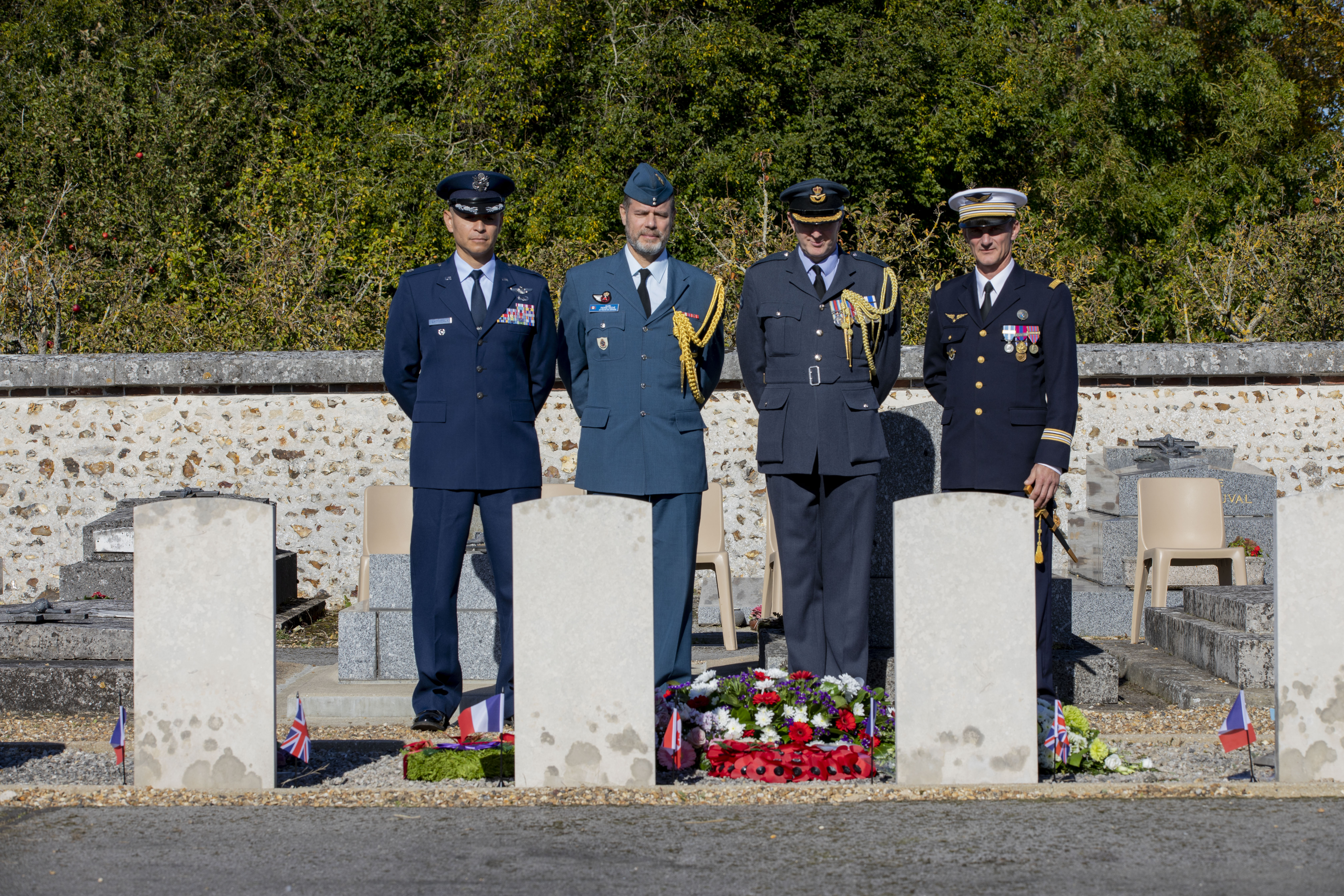 Personnel stand by headstones.